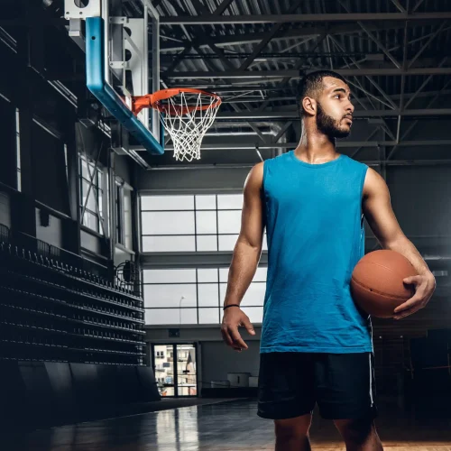 black-basketball-player-holds-a-ball-over-a-hoop-in-a-basketball