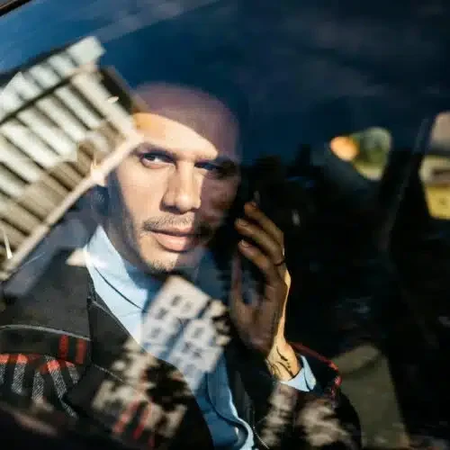 man-sitting-on-back-seat-of-a-car-talking-on-cell-phone-500x500