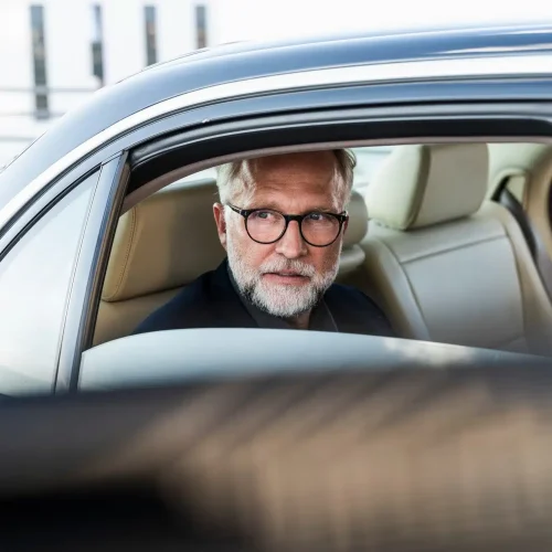 mature-businessman-sitting-on-backseat-in-car-looking-out-of-window