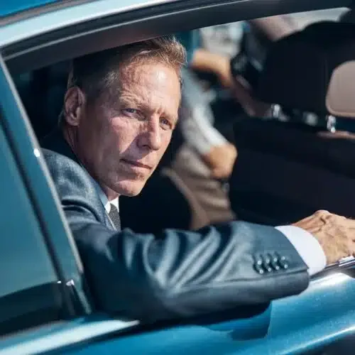 mature-elgant-man-going-by-car-with-chauffeur-500x500