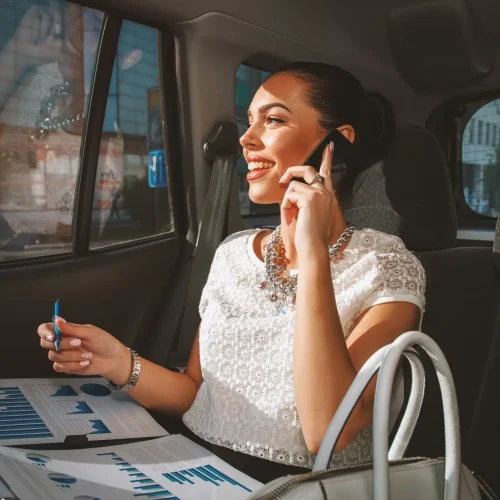 young-businesswoman-talking-on-the-phone-in-the-back-seat-of-the-car